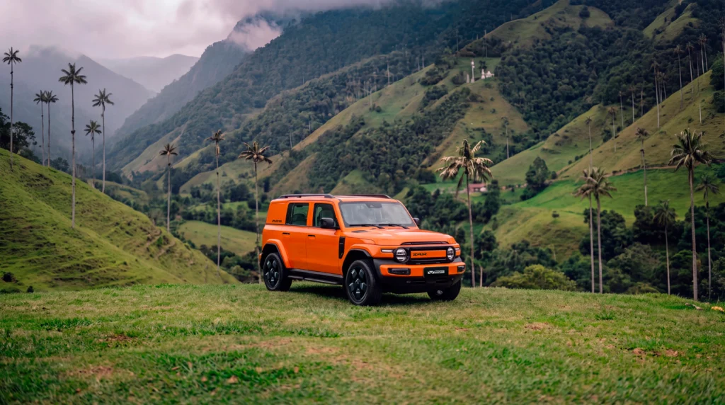 iCAUR V23 EV naranja, SUV 100% eléctrico, en un paisaje de montañas y palmas de cera en Colombia